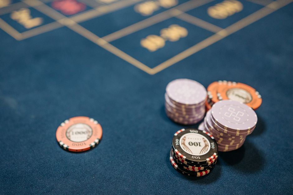 A detailed view of poker chips on a blue gaming table, perfect for gambling themes.